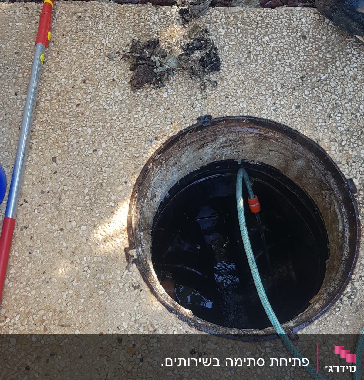 פתח ביוב עם צינור מים וכלי עבודה